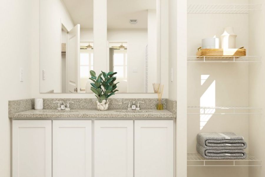 A bathroom with white cabinets.