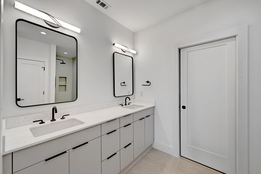 Bathroom with a sink, visible vents, double vanity, and tile patterned floors