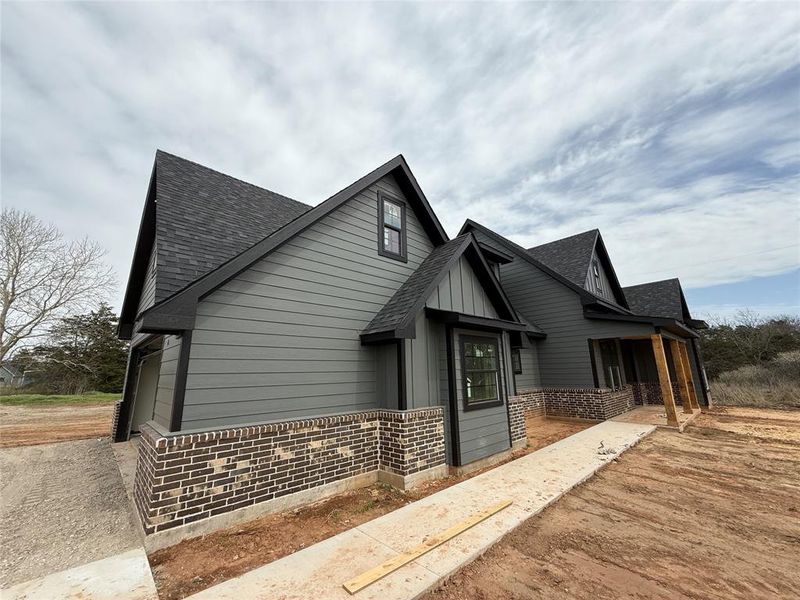 View of home's exterior featuring brick siding and roof with shingles