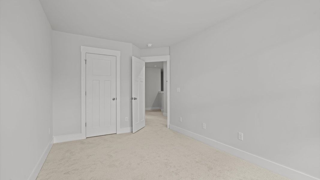 Elegant bedroom retreat featuring soft carpeting and a thoughtfully designed walk-in closet Elegant bedroom retreat featuring soft carpeting and a thoughtfully designed walk-in closet