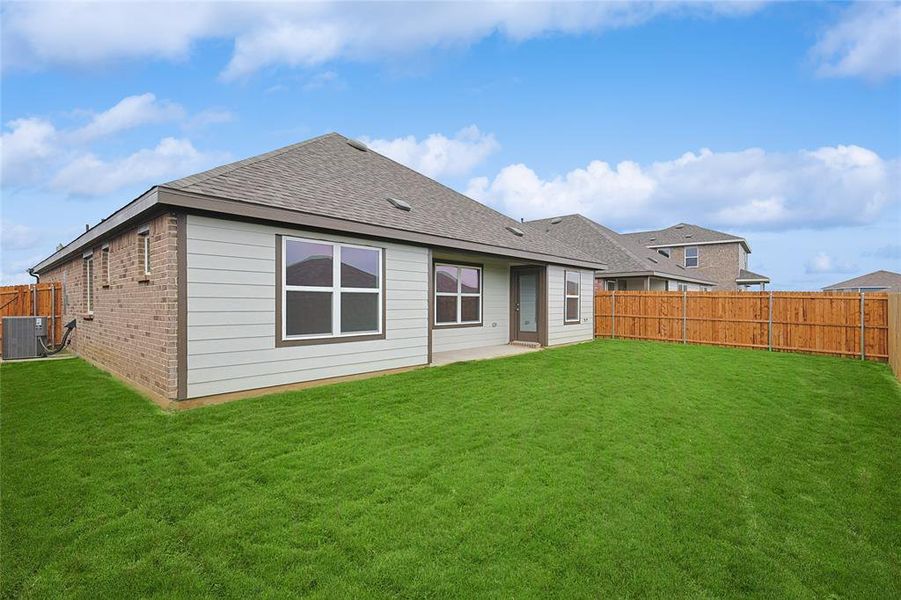 Rear view of house featuring a yard, a patio, and central AC unit