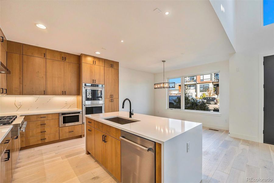 Gourmet kitchen with solid wood cabinets, quartz countertops and waterfall island