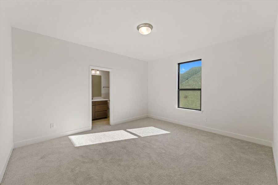 Unfurnished bedroom with light carpet and ensuite bath