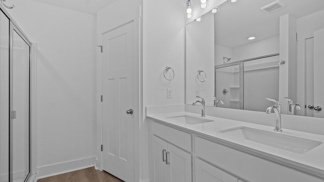 Notable primary bath featuring dual vanity, walk-in shower, and tasteful design touches throughout Notable primary bath featuring dual vanity, walk-in shower, and tasteful design touches throughout