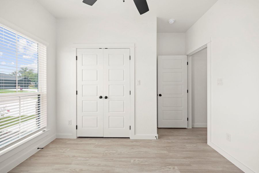 A quiet retreat with a window overlooking the neighborhood and a ceiling fan for comfort.