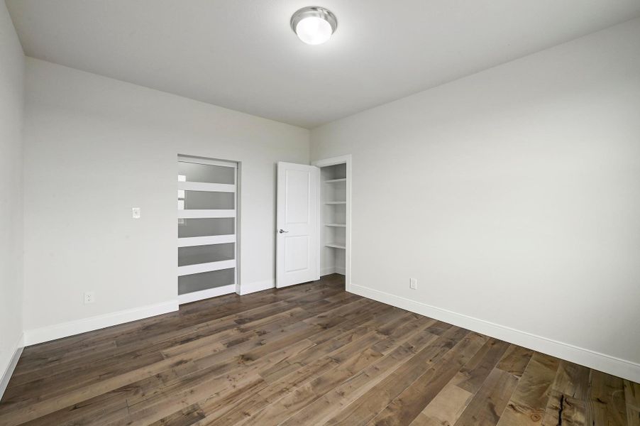 Unfurnished bedroom featuring dark wood finished floors and a closet