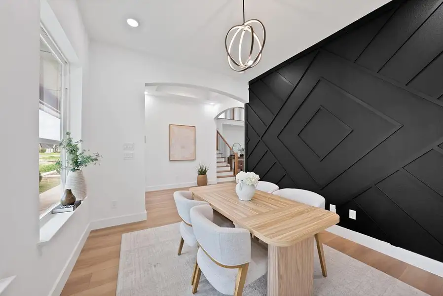 Dining area featuring a modern black accent wall with geometric paneling