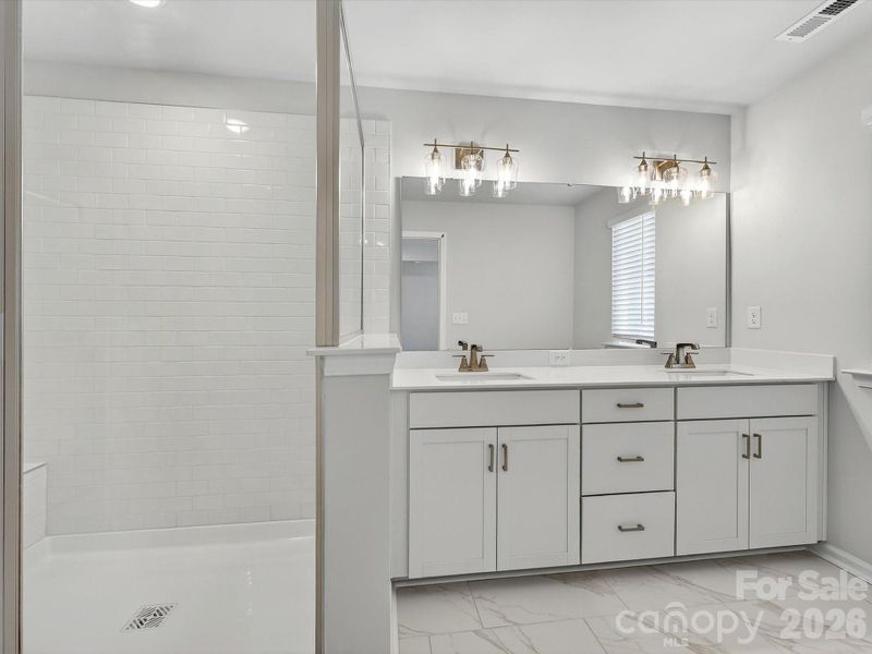 Dual owners' vanity with soft close doors and drawers, quartz countertops, tiles shower with bench. 12x14 tiled floors