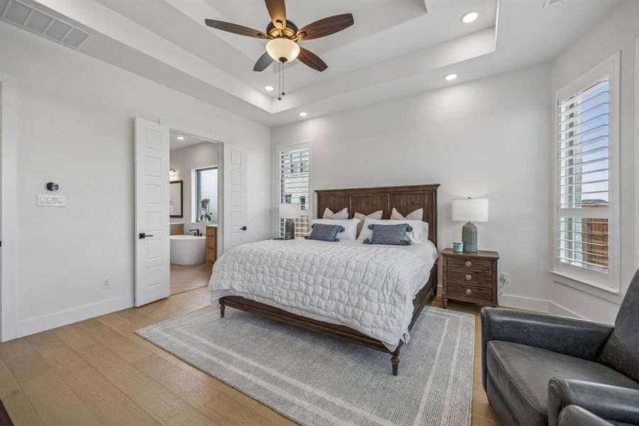 Bedroom with hardwood / wood-style floors, recessed lighting, ceiling fan, and ensuite bathroom
