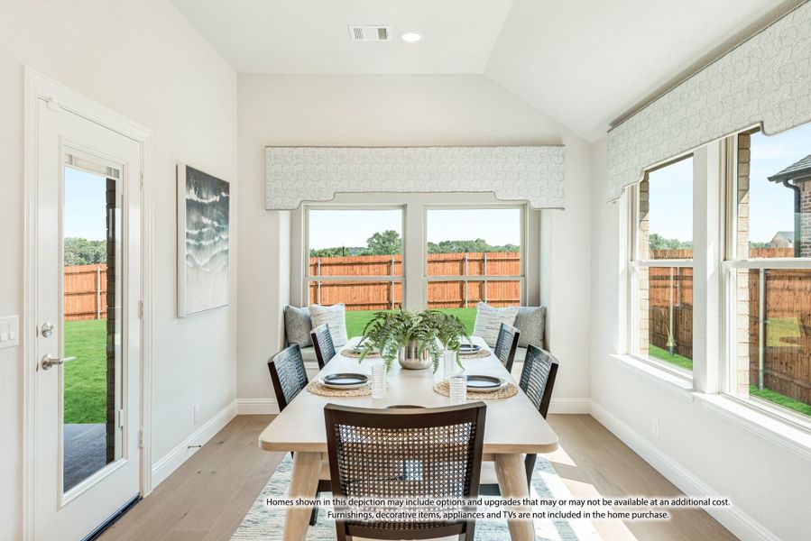 Bright dining area with vaulted ceiling, wood table, and large windows overlooking fenced backyard Bright dining area with vaulted ceiling, wood table, and large windows overlooking fenced backyard