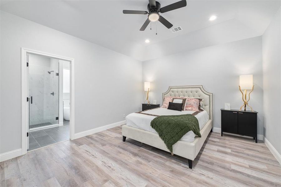 Bedroom with ceiling fan, ensuite bath, and light hardwood / wood-style floors