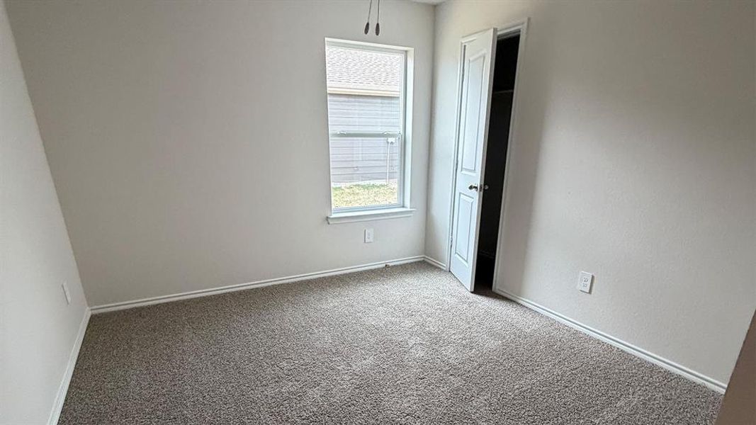Unfurnished bedroom featuring light colored carpet and baseboards
