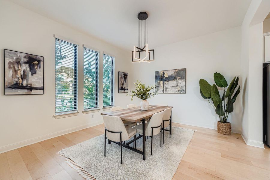 Dining space with light wood-style floors and a chandelier Dining space with light wood-style floors and a chandelier