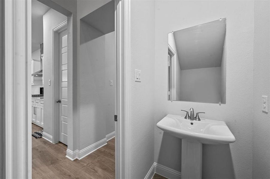 Bathroom with wood finished floors and baseboards