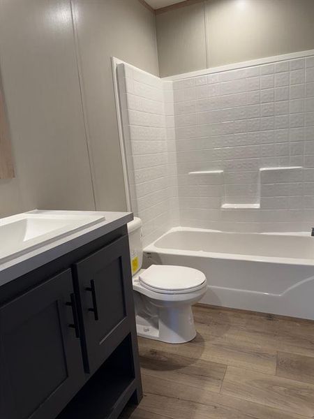 Bathroom with dark wood finished floors, vanity, and shower / washtub combination Bathroom with dark wood finished floors, vanity, and shower / washtub combination