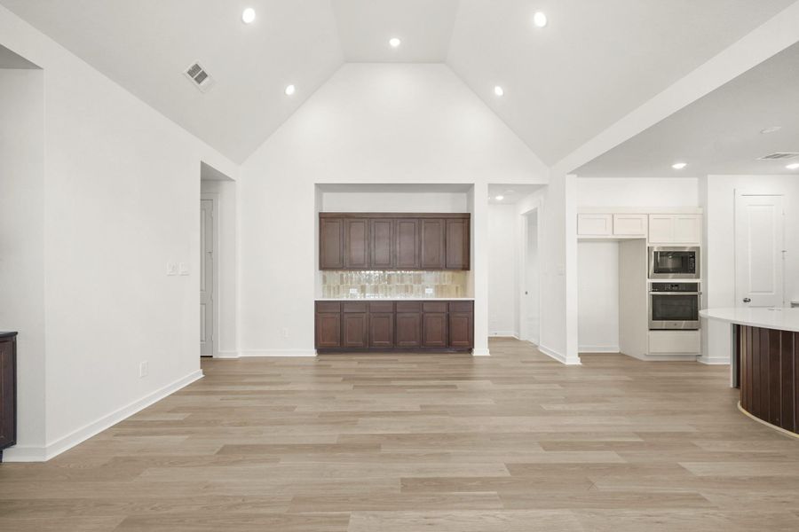 A beautiful dining area with a high ceiling, built-in cabinets, and a hutch that adds both charm and functionality. A beautiful dining area with a high ceiling, built-in cabinets, and a hutch that adds both charm and functionality.