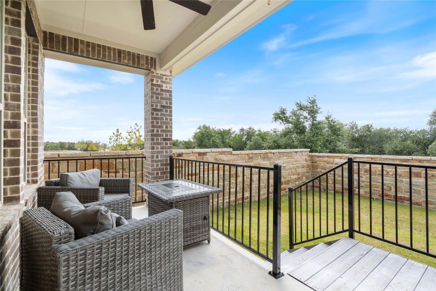 The covered patio includes a ceiling fan and overlooks the fully fenced backyard.