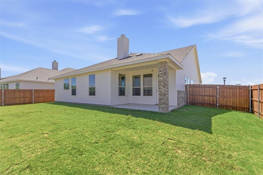 Back of house featuring a patio area, a chimney, a fenced backyard, and a shingled roof