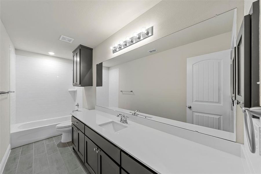 Full bathroom featuring vanity, shower / bathtub combination, recessed lighting, and light tile patterned floors Full bathroom featuring vanity, shower / bathtub combination, recessed lighting, and light tile patterned floors