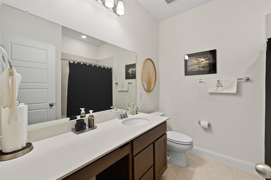 Bathroom featuring light tile patterned flooring, vanity, and curtained shower Bathroom featuring light tile patterned flooring, vanity, and curtained shower