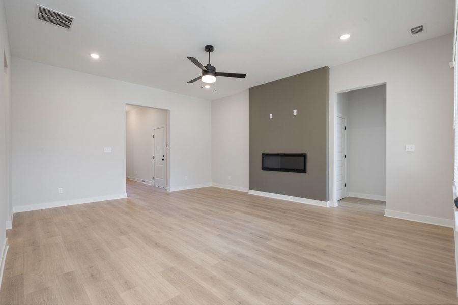 Open-concept living area featuring wood-finish flooring, recessed lighting, and a ceiling fan Open-concept living area featuring wood-finish flooring, recessed lighting, and a ceiling fan
