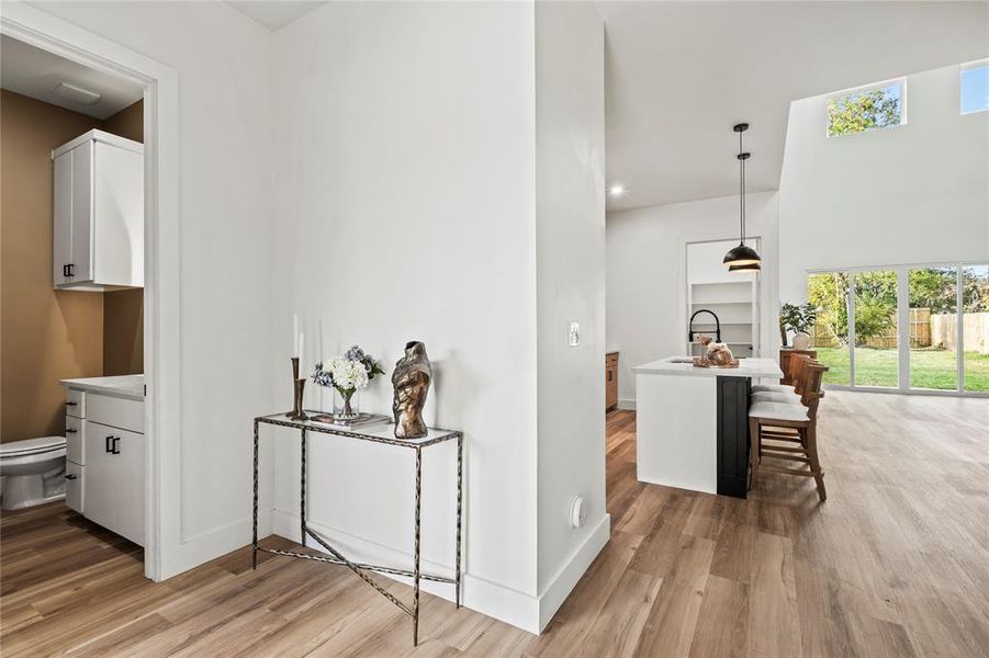 Hall with light wood-style floors and a towering ceiling