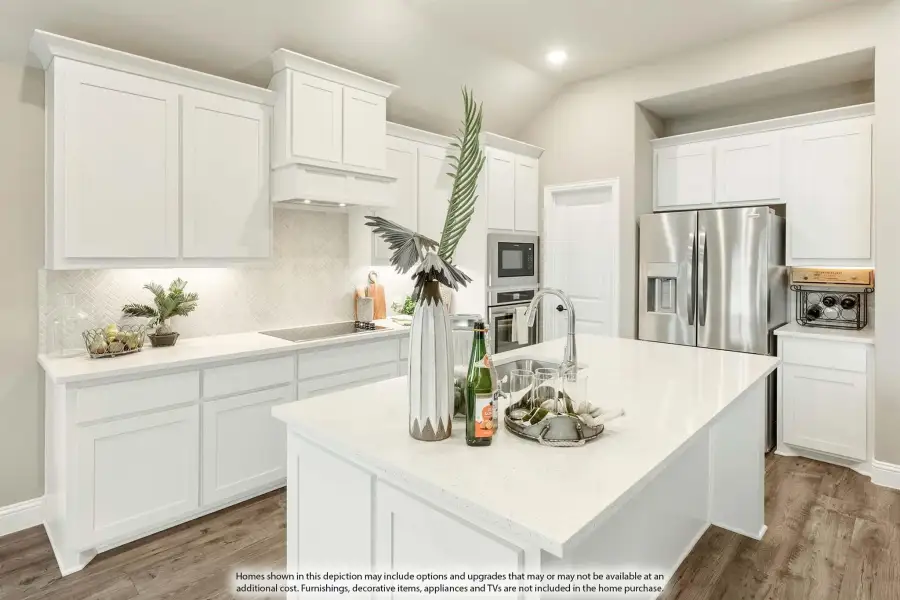 Kitchen with white cabinets, center island, stainless steel appliances, and herringbone tile backsplash on hardwood floors