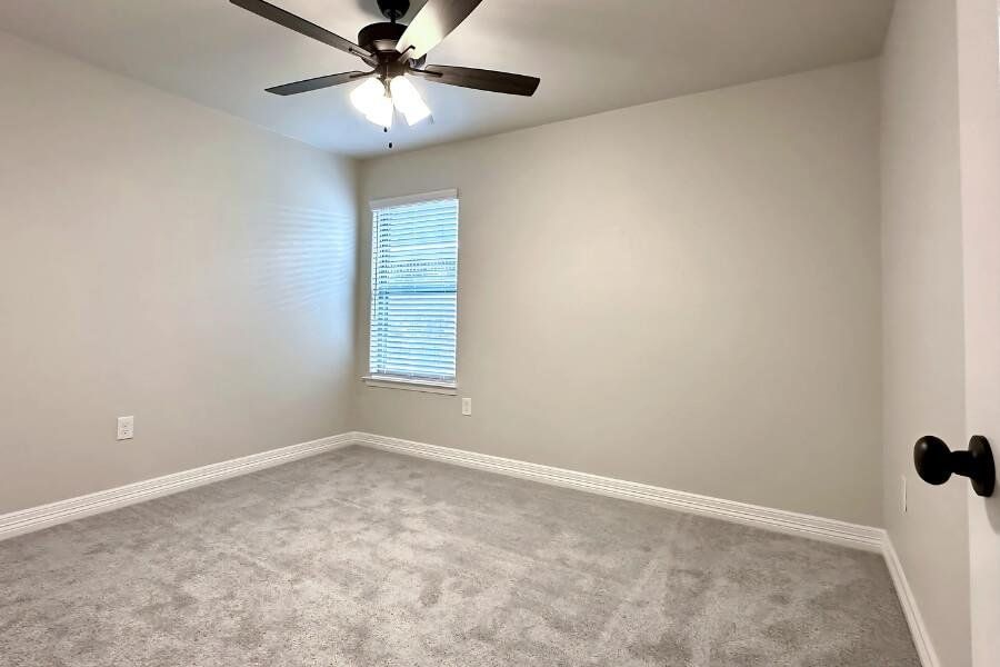 Empty room with carpet flooring and ceiling fan