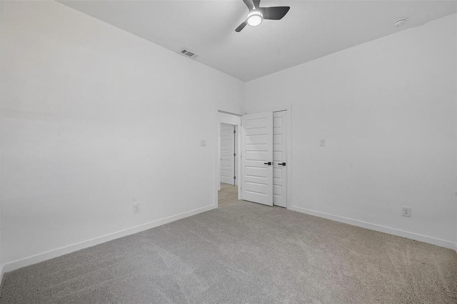 Unfurnished room featuring carpet flooring and ceiling fan Unfurnished room featuring carpet flooring and ceiling fan