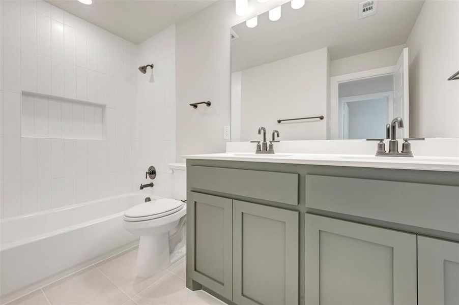Modern bathroom featuring a dual vanity with light gray cabinetry, a white countertop, and brushed nickel fixtures