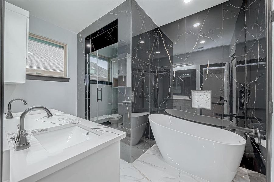 Step into the stunning primary bathroom with modern finishes, where white floor tiles contrast beautifully with luxurious black tiles adorned with gold details on the shower and soaking tub wall from floor to ceiling.