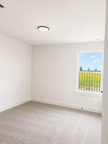 Additional bedroom featuring soft neutral tones, plush carpeting, and a bright, airy layout with plenty of natural light.