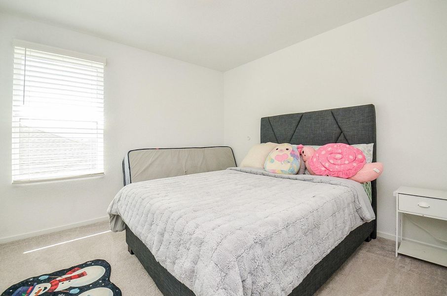 This photo showcases the back of a house featuring a spacious, covered patio perfect for outdoor relaxation and entertaining. The yard is lush and enclosed with a wooden fence, offering privacy and ample space for activities.