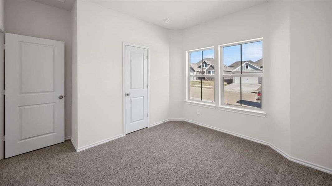 Unfurnished bedroom featuring dark carpet and a residential view