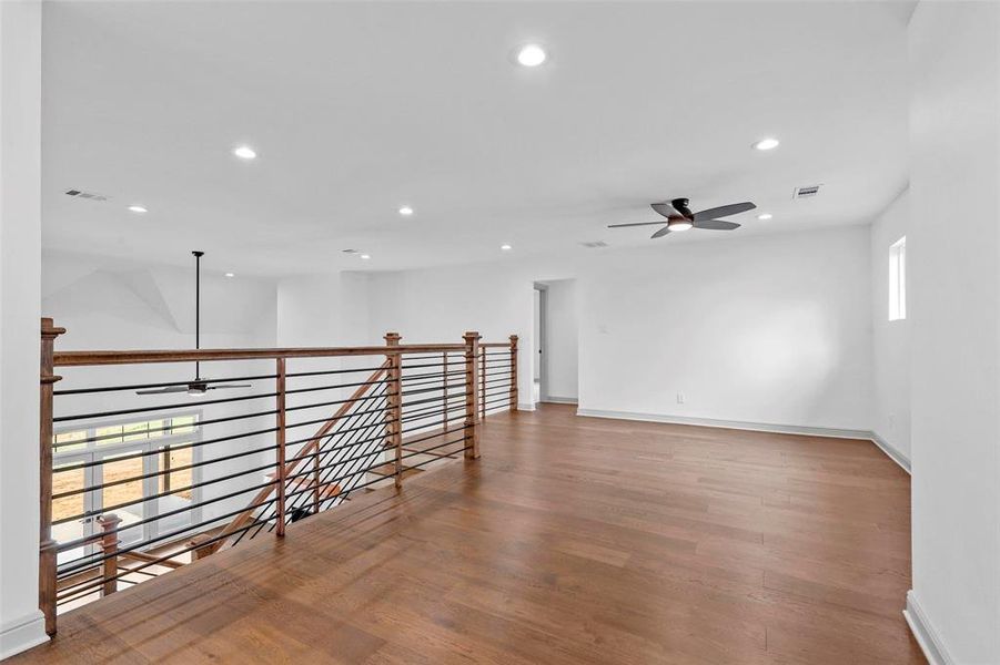 Empty room featuring hardwood / wood-style flooring and ceiling fan