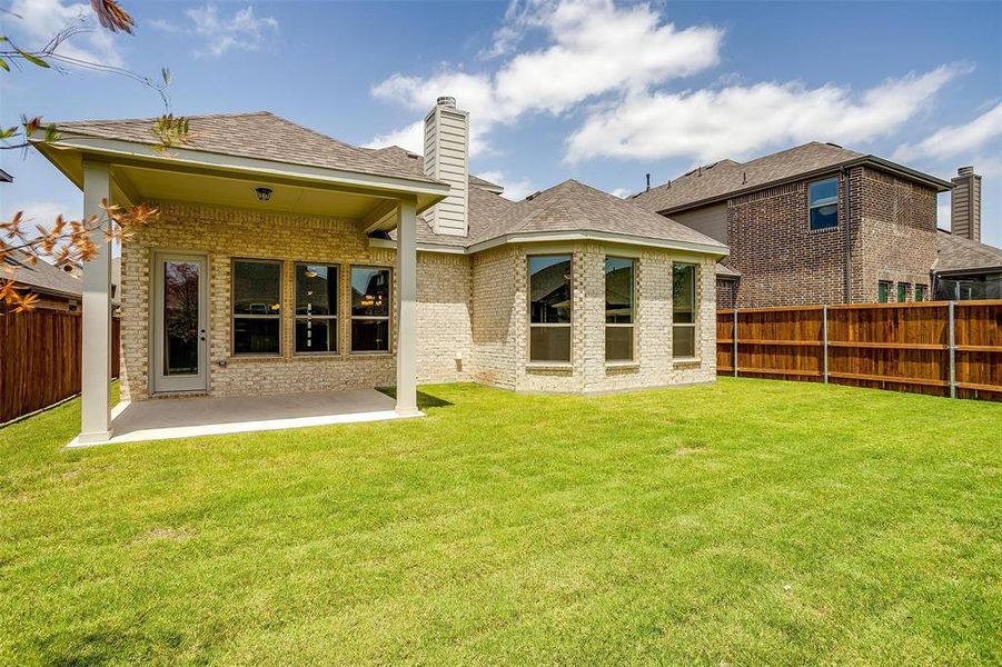 Back of house with a patio and a lawn