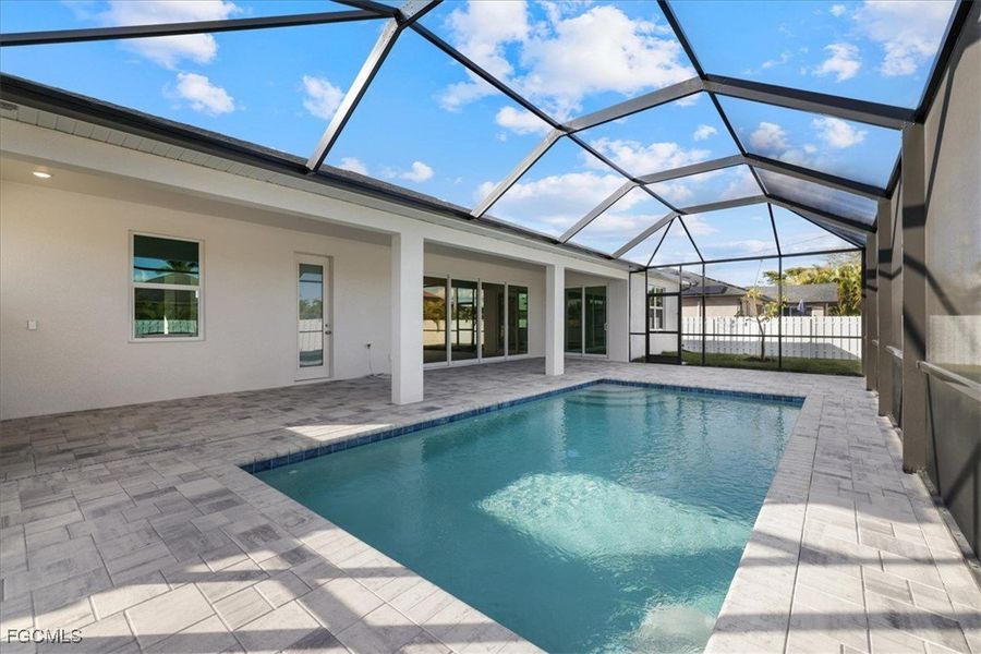 View of pool featuring a sunroom, a patio area, and a lanai View of pool featuring a sunroom, a patio area, and a lanai