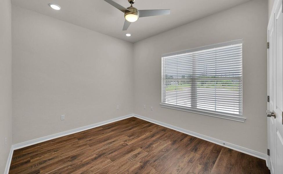 Empty room featuring dark wood-style floors, ceiling fan, and recessed lighting
