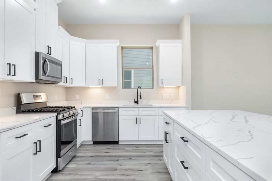 The kitchen provides ample storage and thoughtful features such as soft-close cabinets and drawers as well as under-cabinet lighting.