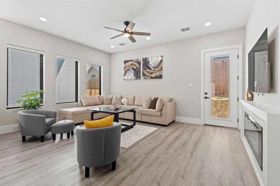 Living room with light wood-type flooring, recessed lighting, and a ceiling fan