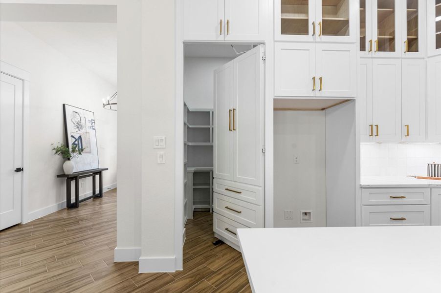 Disguised with a cabinet-style door, the hidden pantry opens to a huge walk-in storage space—ideal for organization and convenience. Disguised with a cabinet-style door, the hidden pantry opens to a huge walk-in storage space—ideal for organization and convenience.