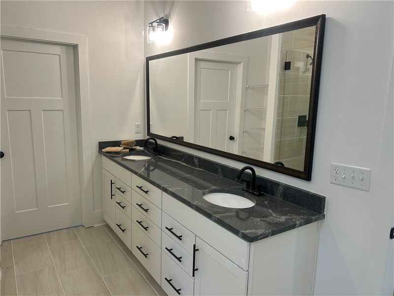 This primary bathroom features a dual vanity with This primary bathroom features a dual vanity with