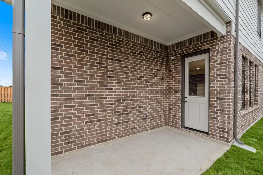 The covered patio is generously sized, providing ample space for various outdoor activities.