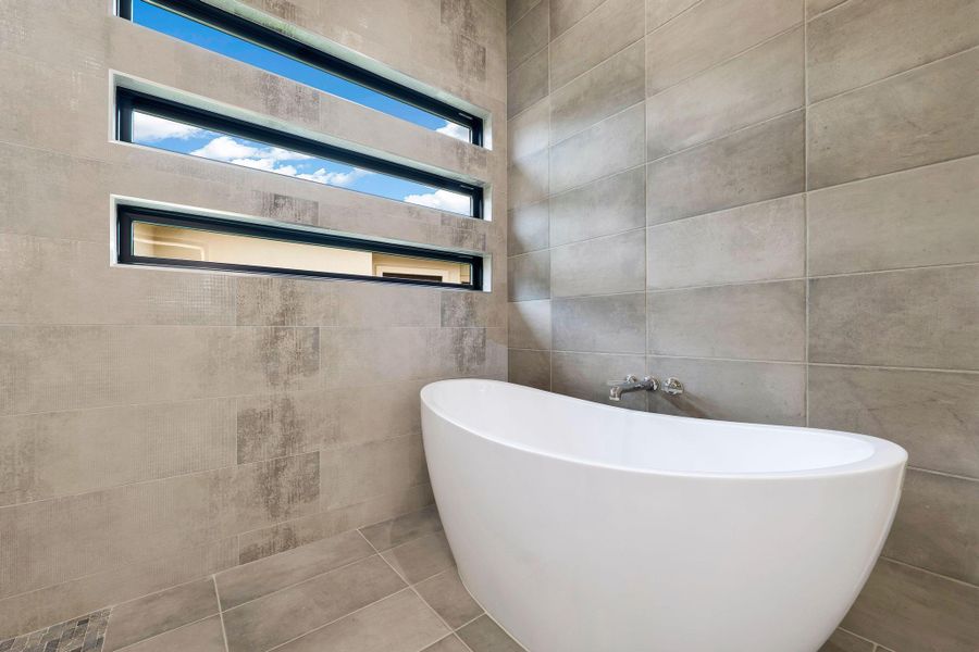 Modern freestanding bathtub with wall-mounted chrome fixtures