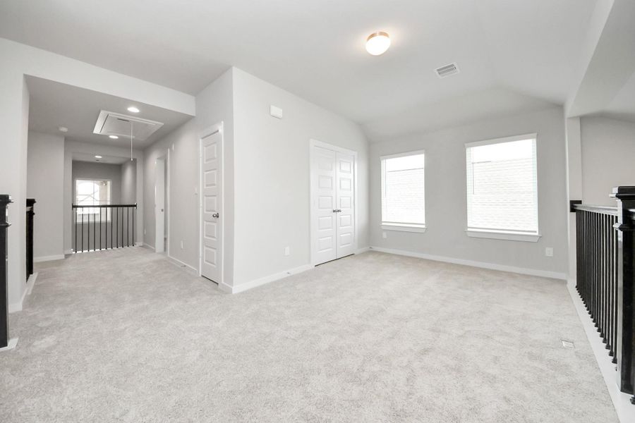 Ascend to relaxation in this fantastic game room! Ideal for both casual gatherings and adult gaming, it boasts plush carpet, lofty ceilings, custom paint, and ample windows for abundant natural light. Sample photo of completed home with similar floor plan. Actual colors and selections may vary.