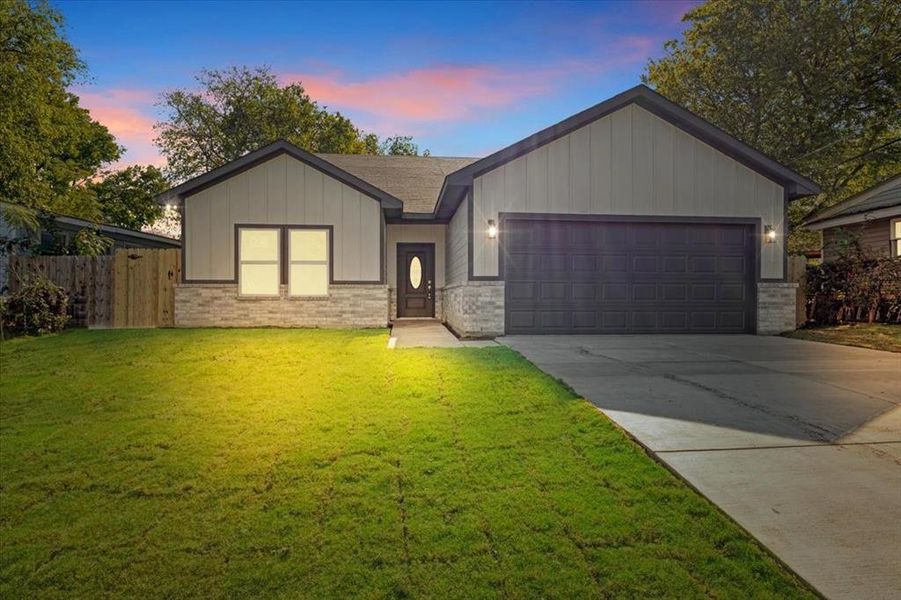 View of front of house featuring a yard and a garage