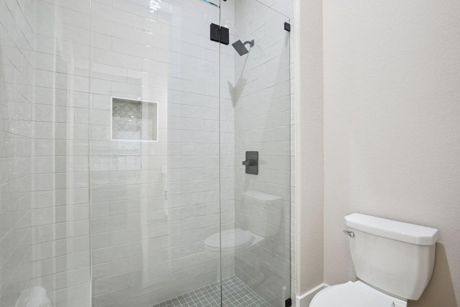 Bathroom featuring a stall shower and toilet