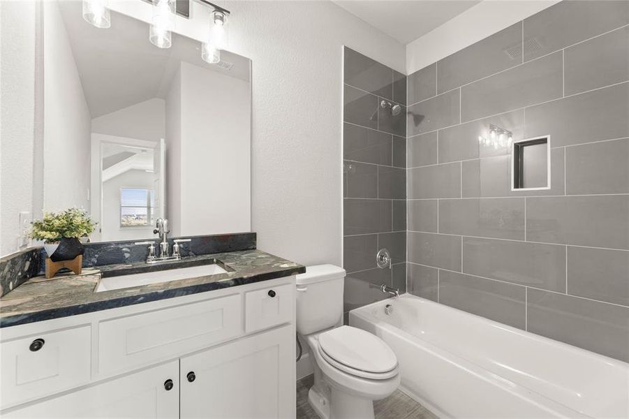 Bathroom featuring washtub / shower combination, vanity, and vaulted ceiling Bathroom featuring washtub / shower combination, vanity, and vaulted ceiling