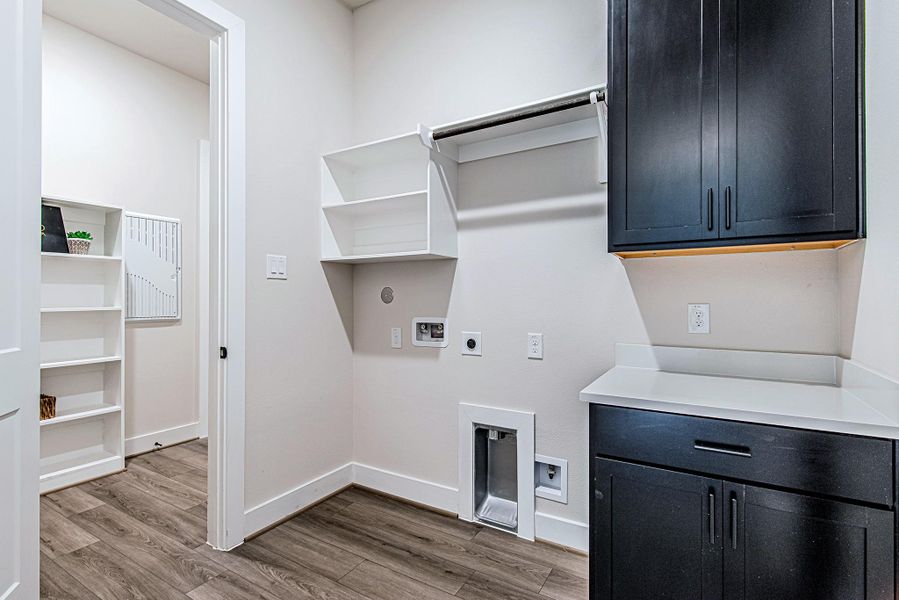 Utility room with built-in cabinetry, open shelving, and space for laundry appliances