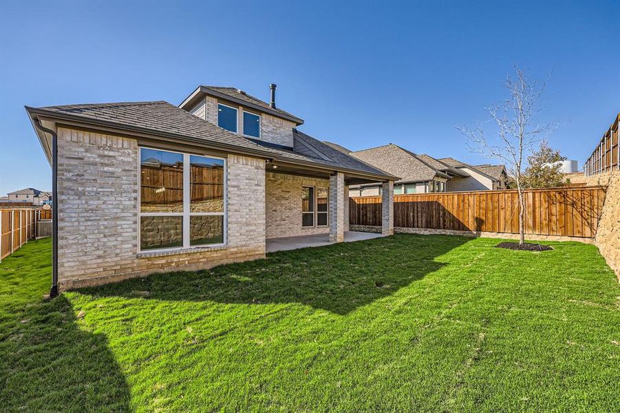 Rear view of house with a patio and a lawn